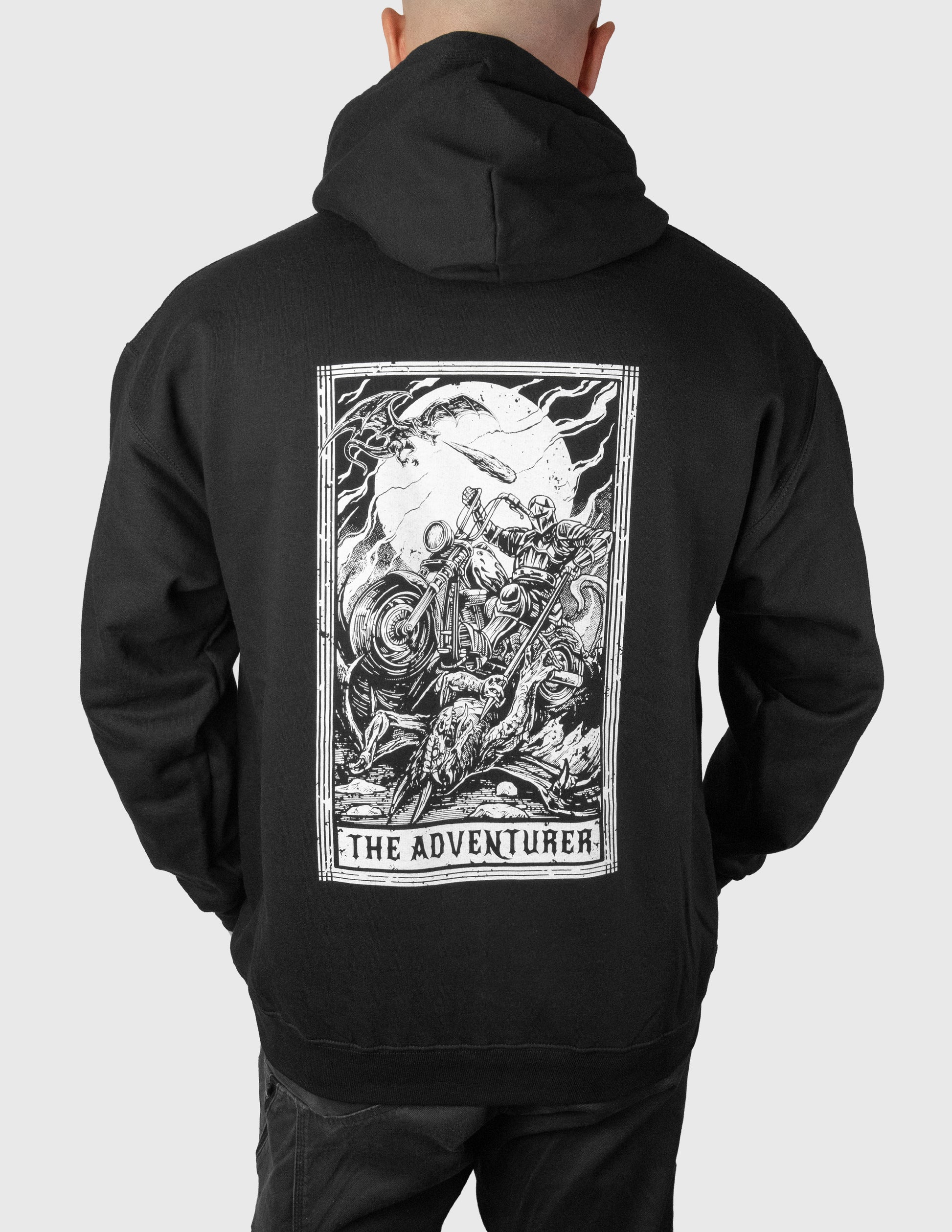 Black hoodie with 'The Adventurer' graphic on the back, worn by a man against a white background