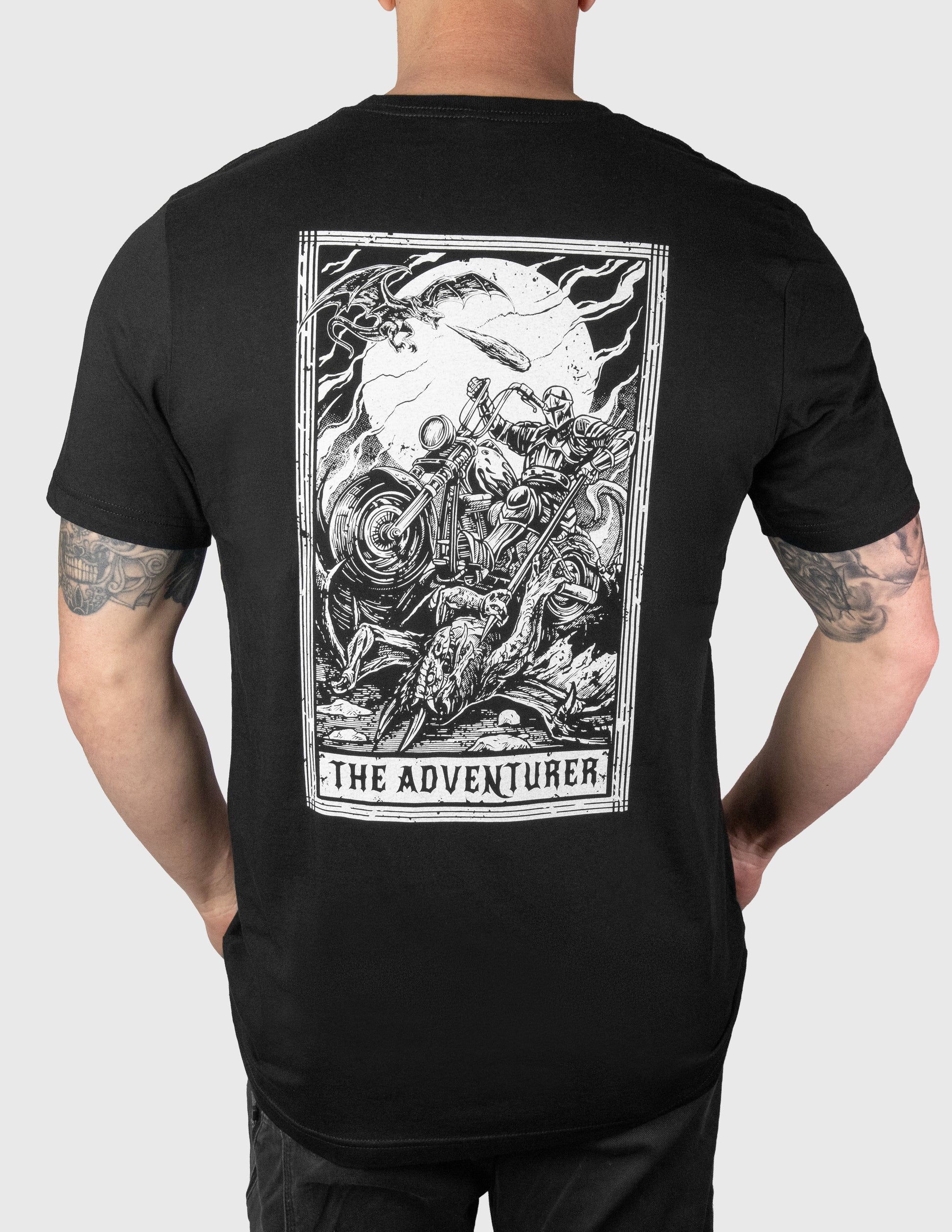 Black t-shirt with 'The Adventurer' graphic on the back, worn by a person.