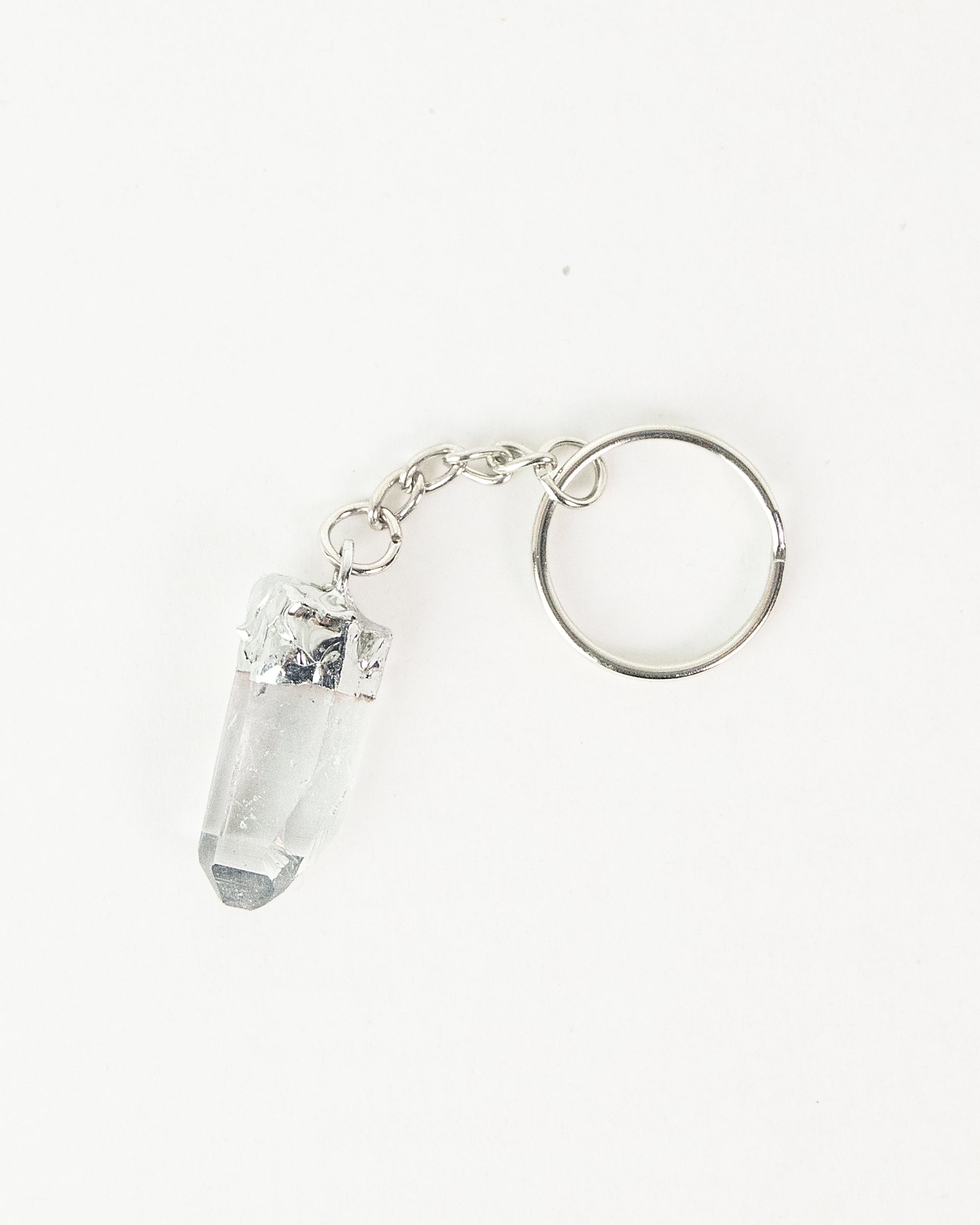 Crystal keychain with silver ring on a white background. Clear Quartz, Her Two Wheels, Mythic Moto, Gremlin Bell, Guardian Bell