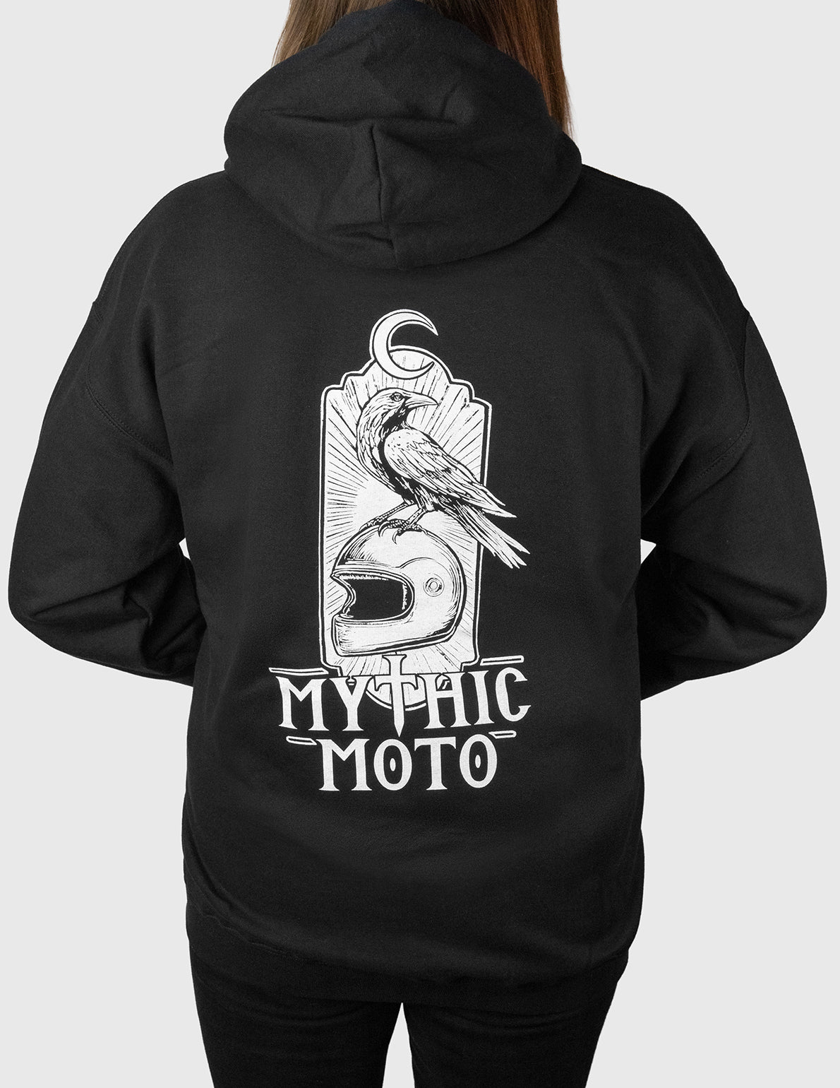 Black hoodie with 'Mythic Moto' design on the back, worn by a woman.