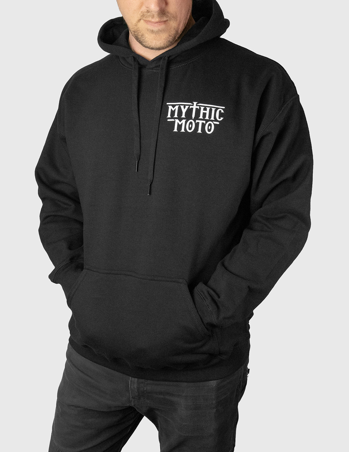 Man wearing a black hoodie with 'Mythic Moto' logo on a white background