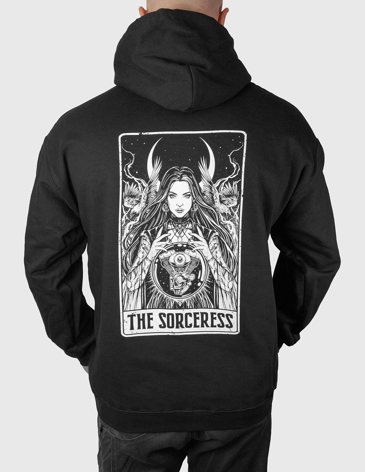 Black hoodie with 'The Sorceress' design on the back, worn by a man against a white background.